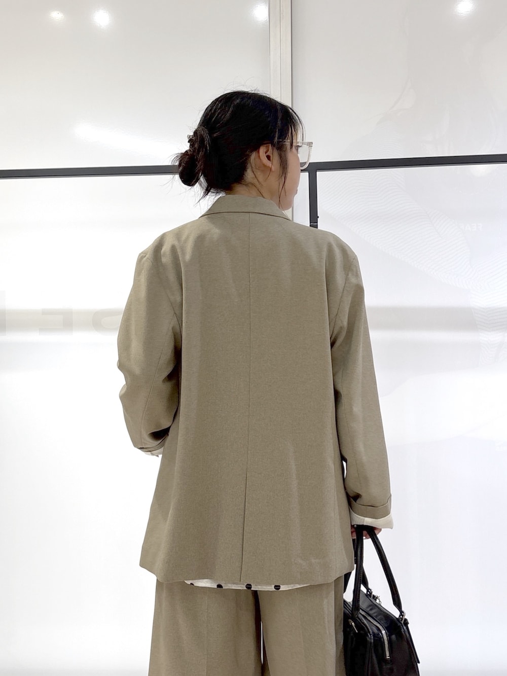 ホワイト系のシャツ/ブラウス、ブラック系のニット/セーター、ベージュ系のテーラードジャケットを着用したレディースの春コーディネートの8枚目の写真