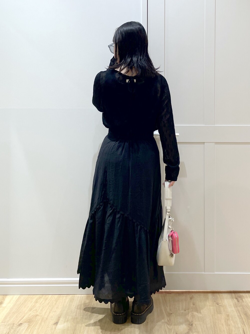 ブラック系のブーツ、ブラック系のスカート、ブラック系のタンクトップを着用したレディースの夏コーディネートの3枚目の写真