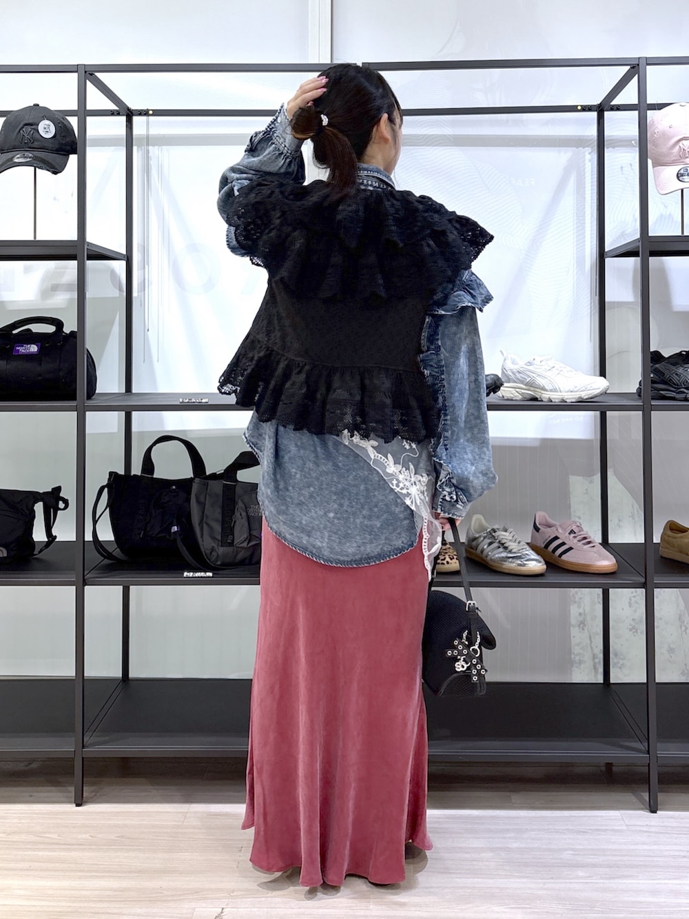 ブラック系のサンダル、ブラック系のショルダーバッグ、レッド系のスカートを着用したレディースの春コーディネートの3枚目の写真