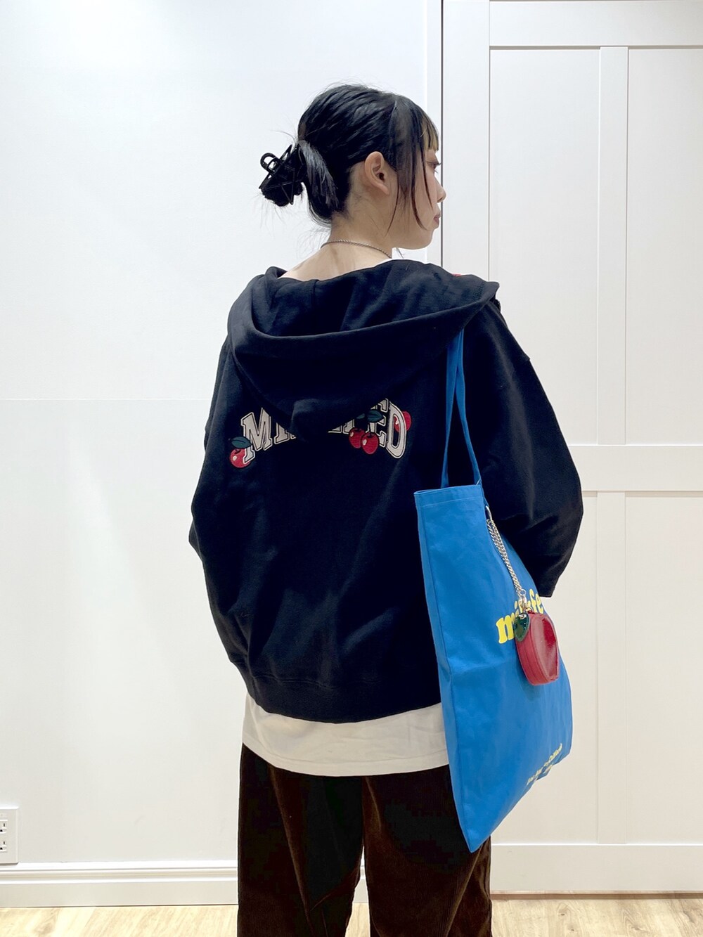 ブルー系のトートバッグ、ホワイト系のTシャツ/カットソー、ブラック系のパーカーを着用したレディースの冬コーディネートの4枚目の写真