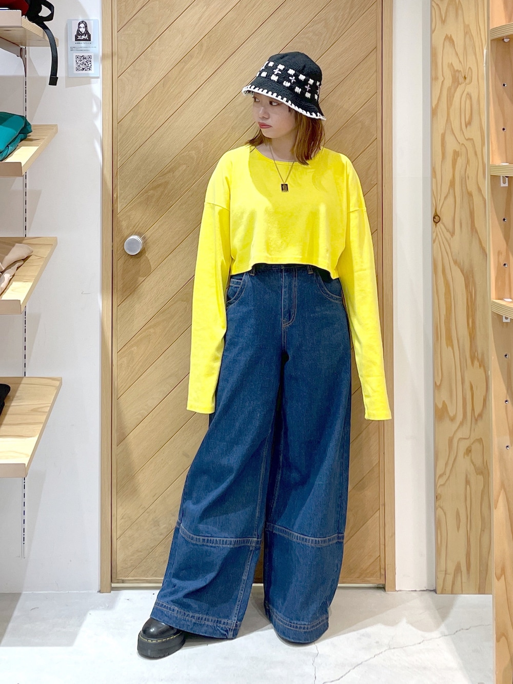 ブルー系のデニムパンツ、イエロー系のTシャツ/カットソー、ブラック系のパーカーを着用したレディースの秋コーディネートの2枚目の写真