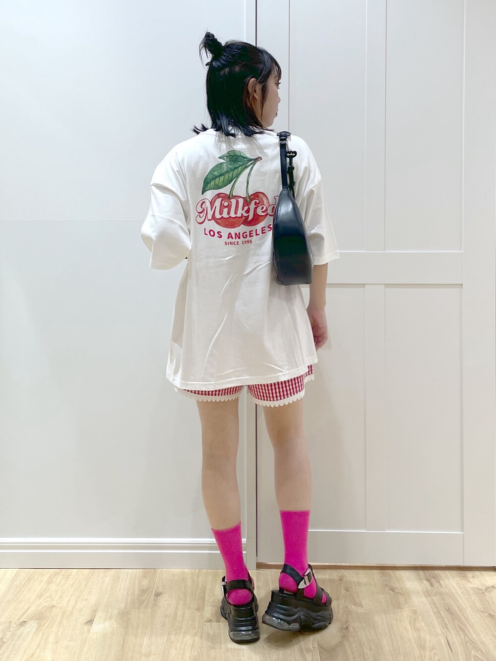 レッド系のその他パンツ、ブラック系のハンドバッグ、ホワイト系のTシャツ/カットソーを着用したレディースの春コーディネートの2枚目の写真
