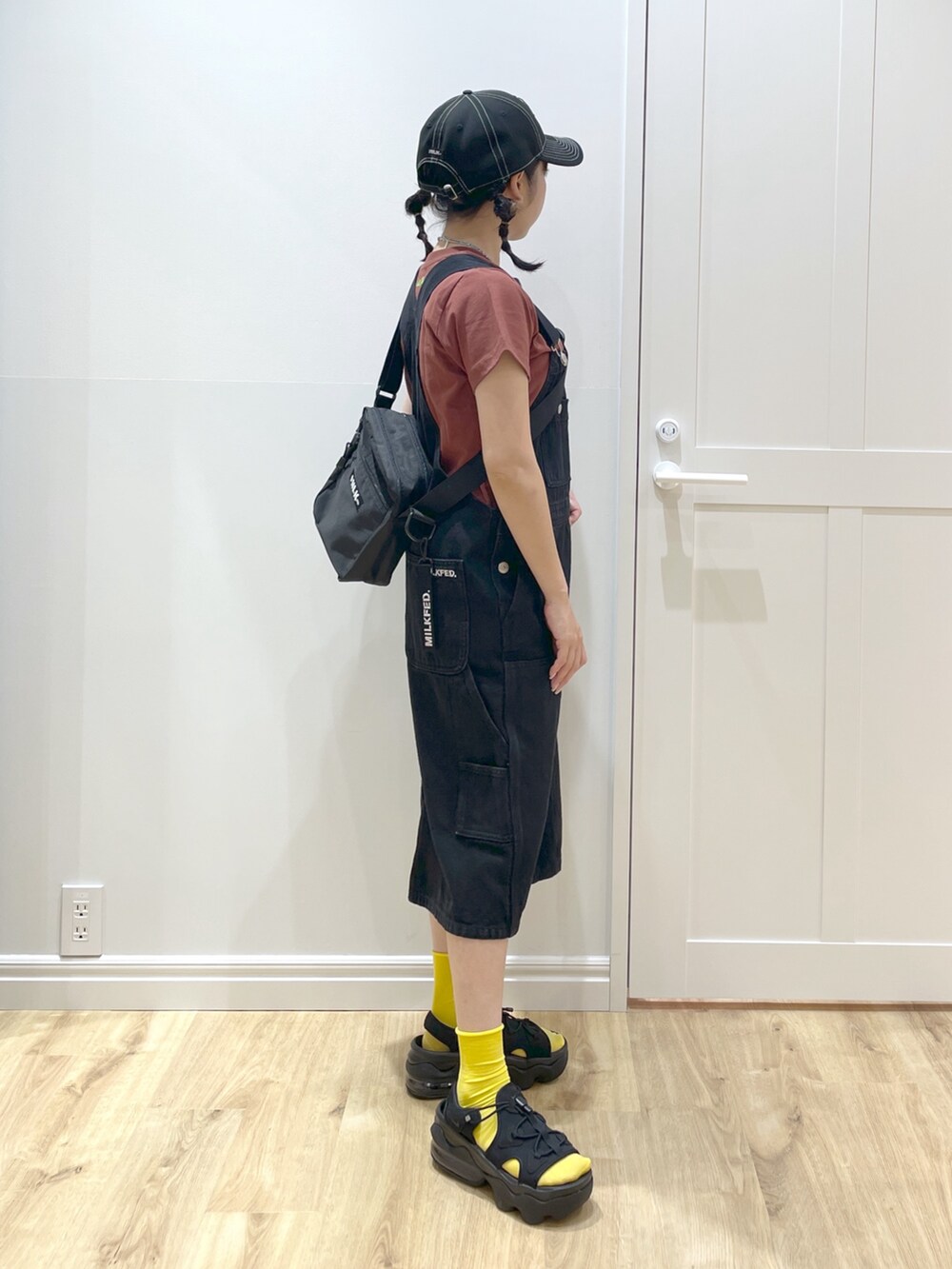 ブラック系のサンダル、ブラック系のサロペット/オーバーオール、ブラウン系のTシャツ/カットソーを着用したレディースの春コーディネートの3枚目の写真