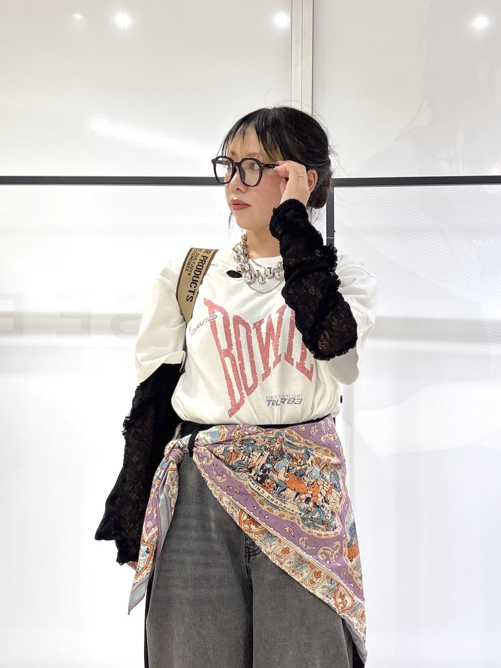 ブラック系のデニムパンツ、シルバー系のスニーカー、ホワイト系のTシャツ/カットソーを着用したレディースの春コーディネートの6枚目の写真