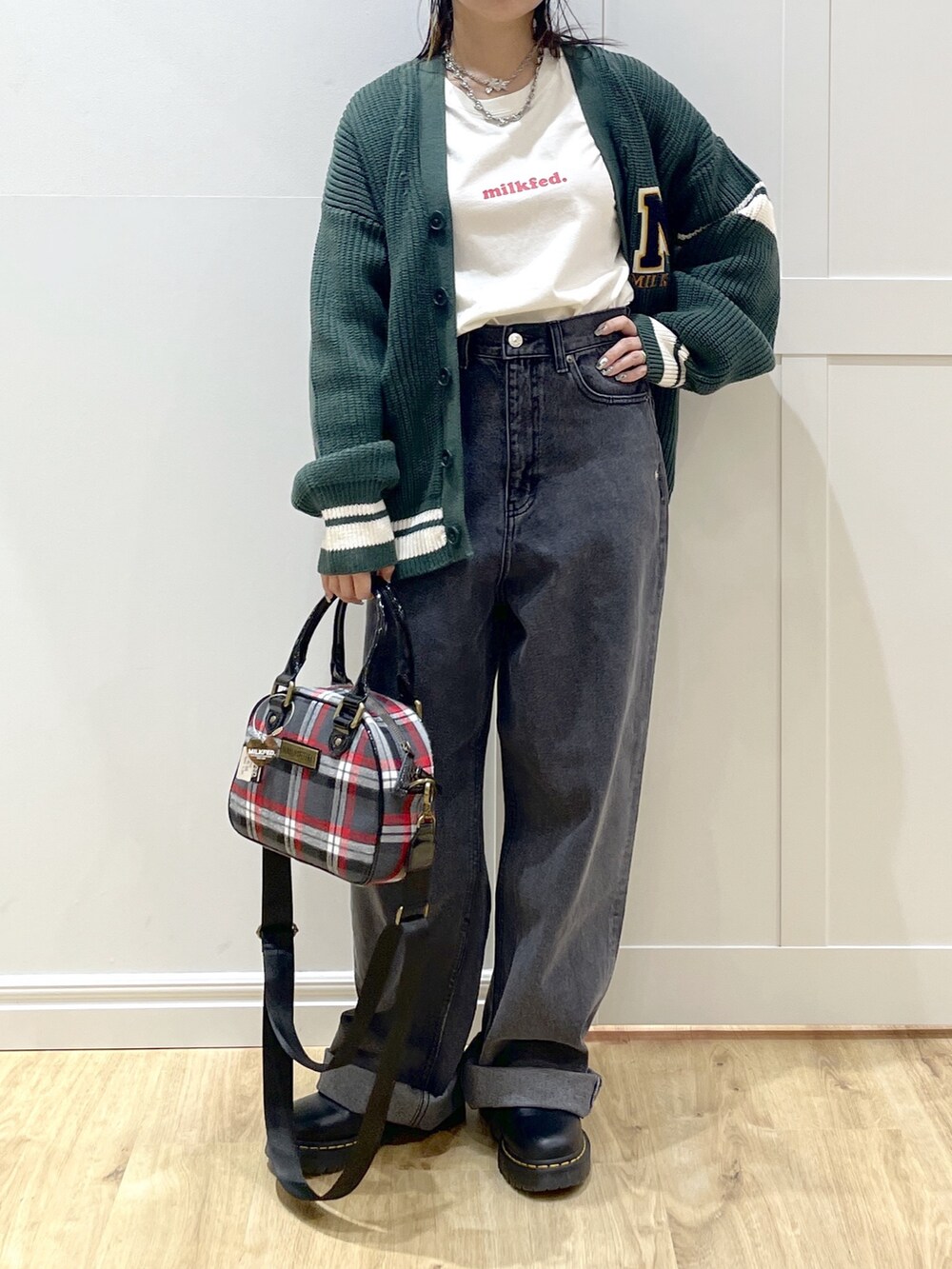 グリーン系のカーディガン/ボレロ、ホワイト系のTシャツ/カットソー、ブラック系のデニムパンツを着用したレディースの秋コーディネートの4枚目の写真