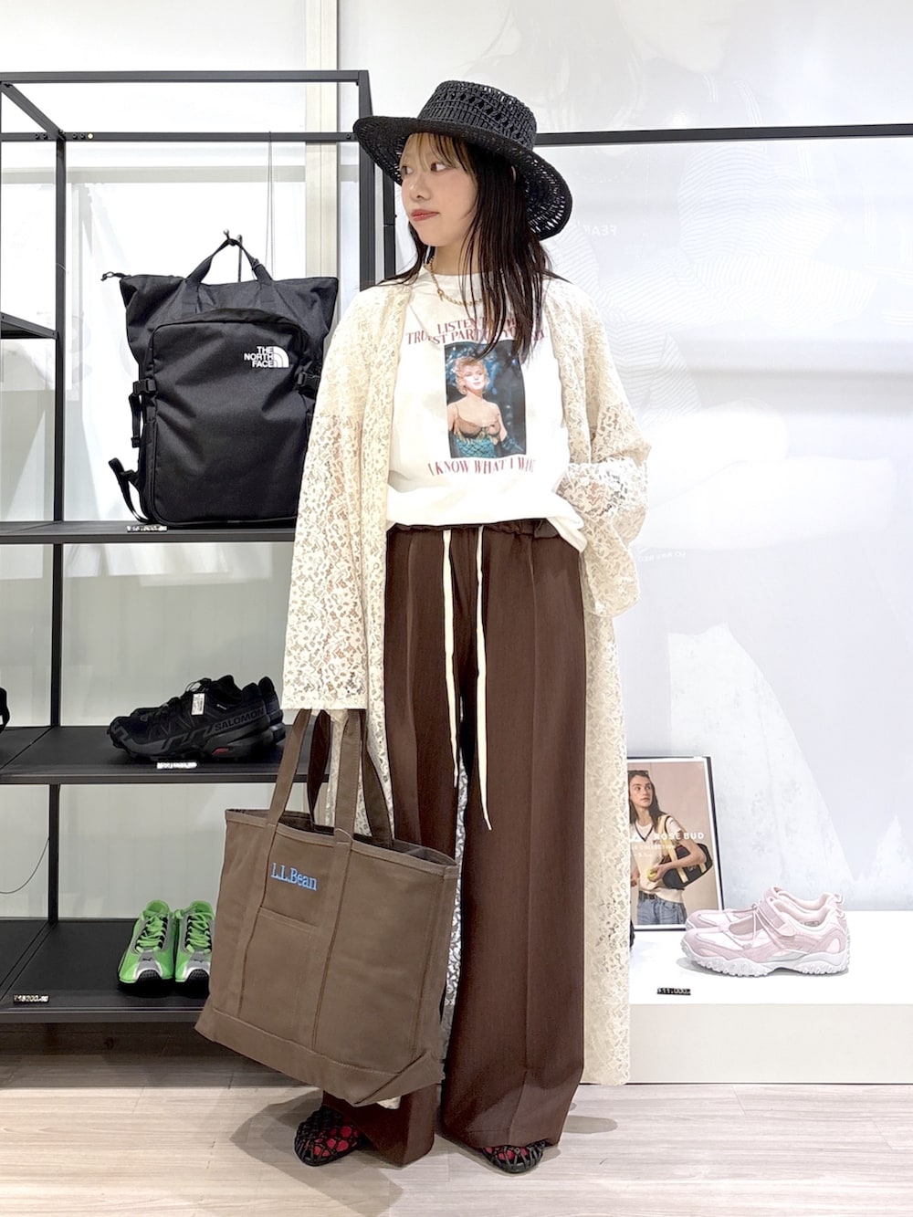 ブラウン系のトートバッグ、ブラウン系のサンダル、ホワイト系のTシャツ/カットソーを着用したレディースの春コーディネートの5枚目の写真