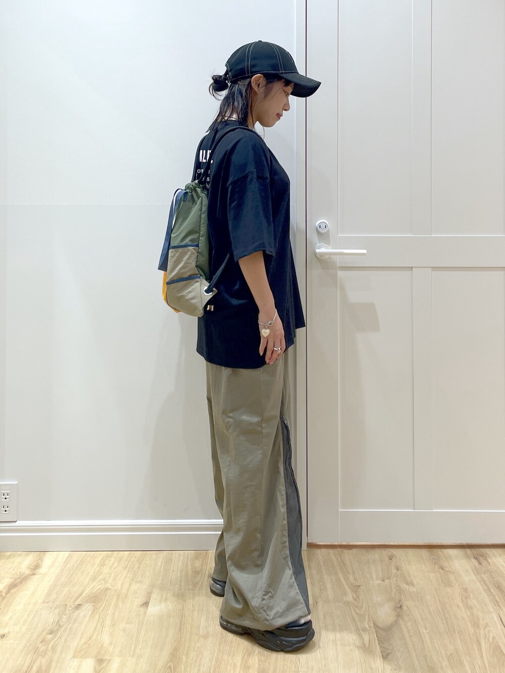 グリーン系のその他パンツ、ブラック系のTシャツ/カットソー、グリーン系のバックパック/リュックを着用したレディースの夏コーディネートの2枚目の写真