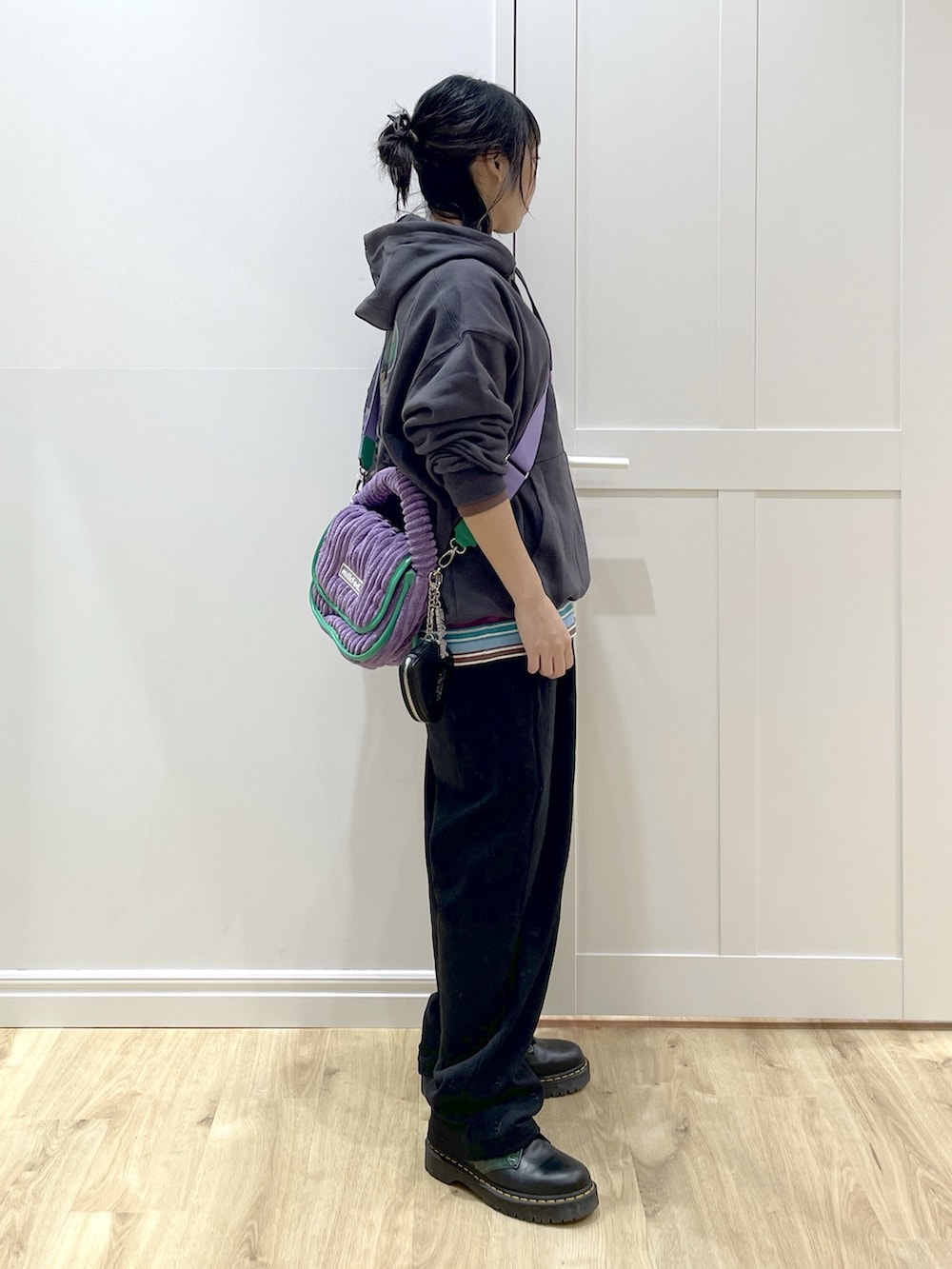 パープル系のショルダーバッグ、グレー系のパーカー、パープル系のTシャツ/カットソーを着用したレディースの秋コーディネートの2枚目の写真