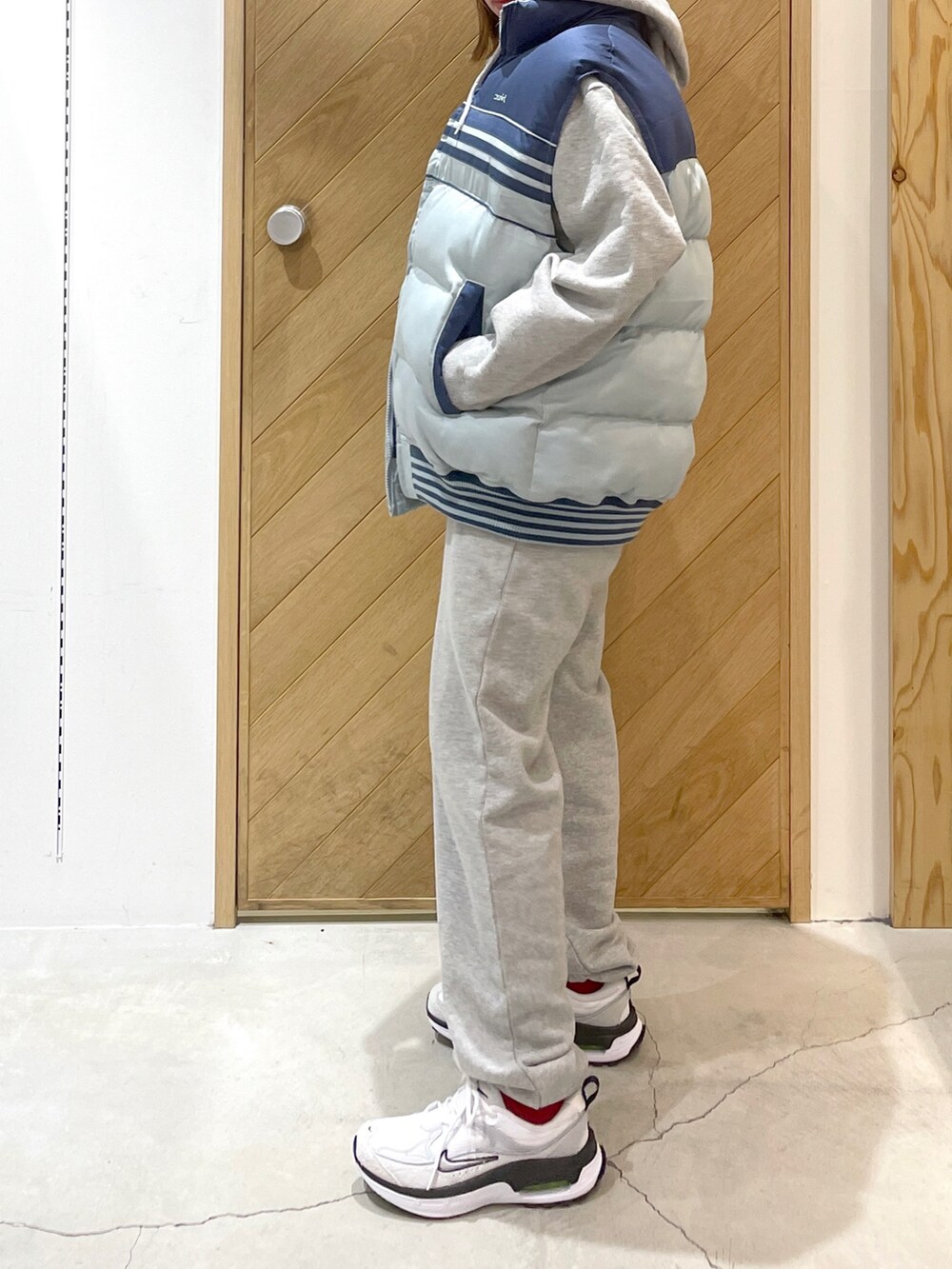 グレー系のパーカー、グレー系のスウェットパンツ、ホワイト系のスニーカーを着用したレディースの冬コーディネートの2枚目の写真