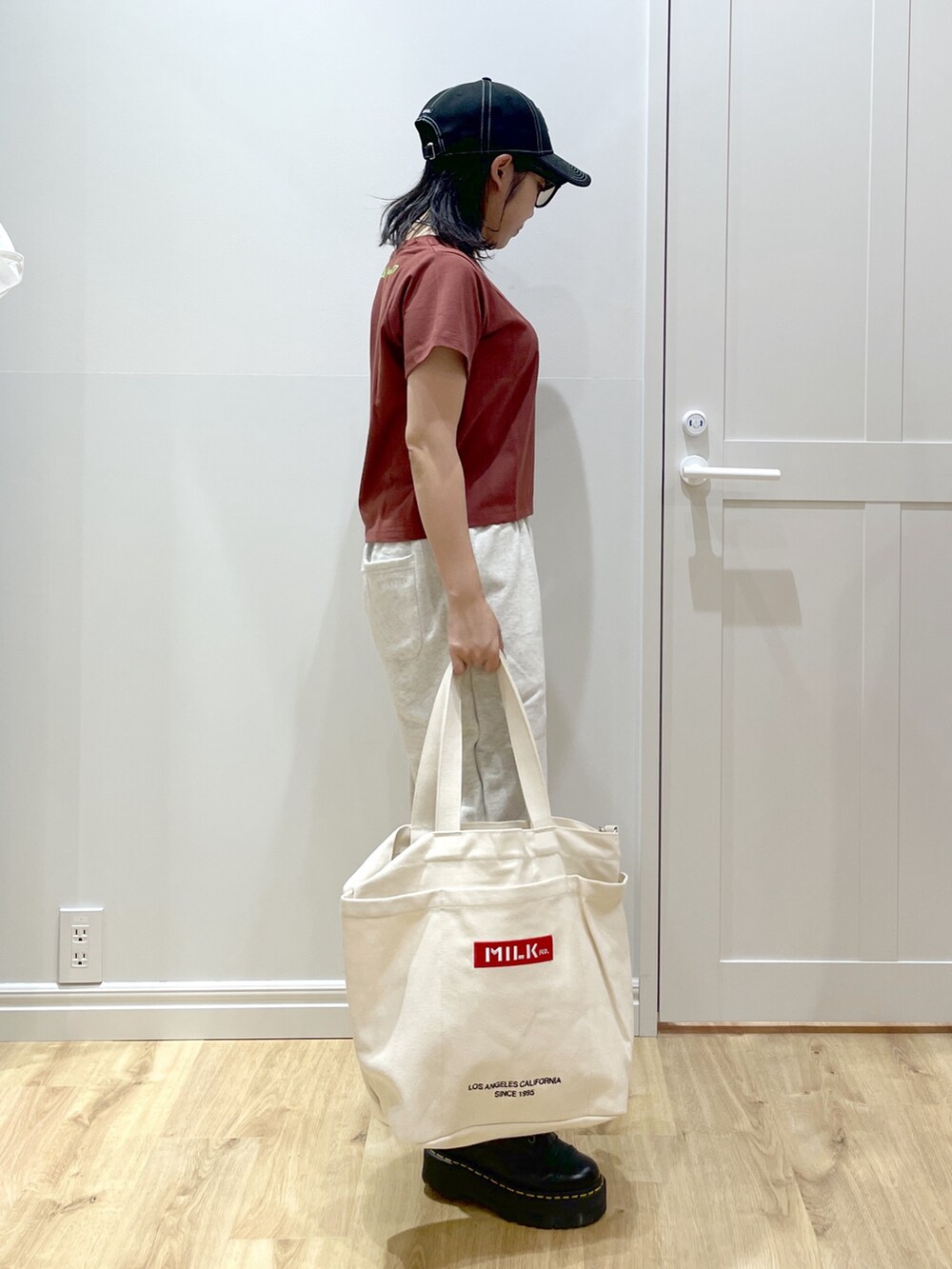 ベージュ系のスウェットパンツ、ブラック系のブーツ、ブラウン系のTシャツ/カットソーを着用したレディースの夏コーディネートの2枚目の写真