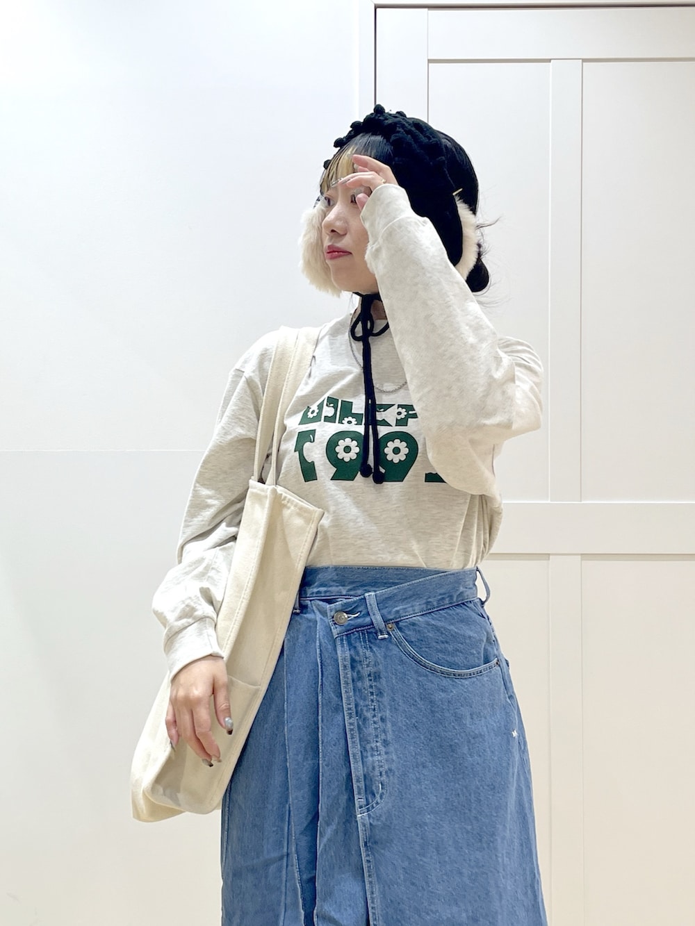 ブルー系のデニムスカート、ベージュ系のTシャツ/カットソー、レッド系のトートバッグを着用したレディースの冬コーディネートの5枚目の写真