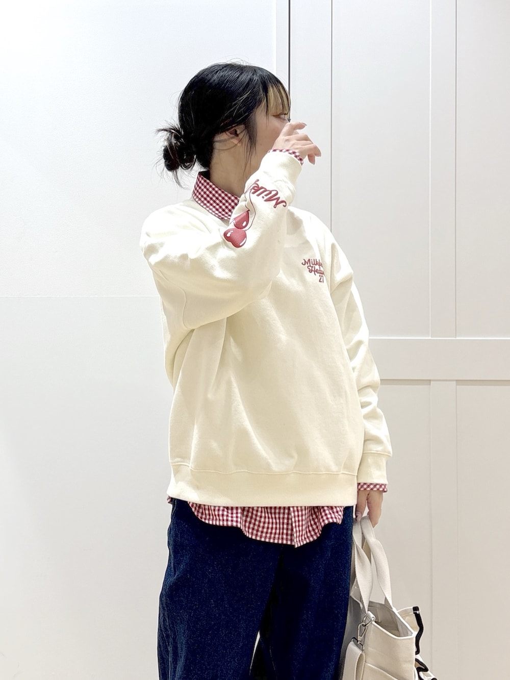 ブルー系のデニムパンツ、レッド系のシャツ/ブラウス、ホワイト系のショルダーバッグを着用したレディースの冬コーディネートの4枚目の写真