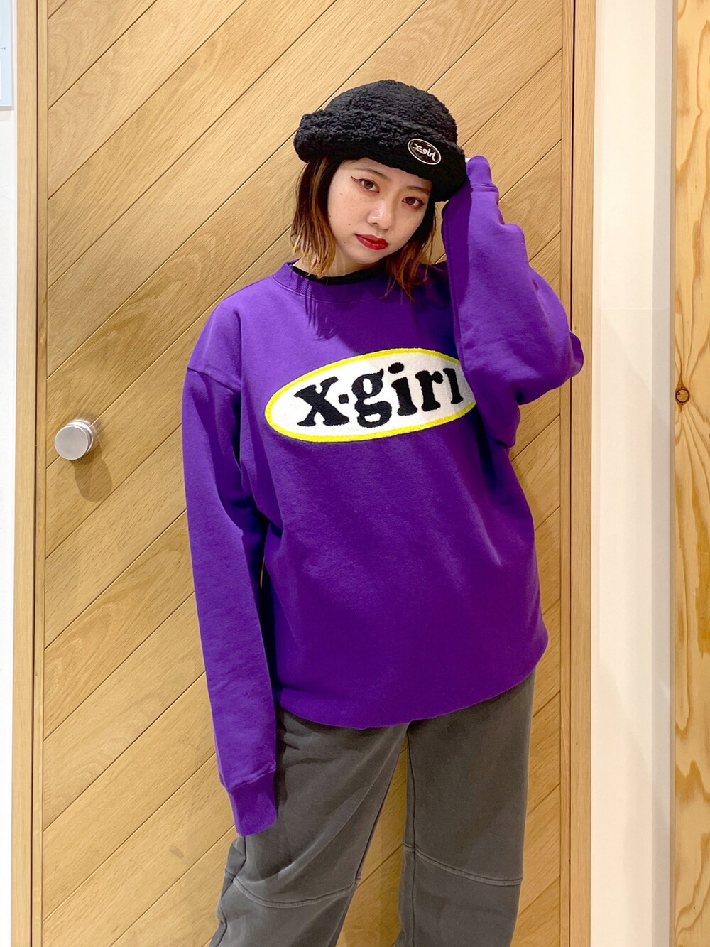 ブラック系のスウェットパンツ、ホワイト系のスニーカー、パープル系のスウェットを着用したレディースの冬コーディネートの3枚目の写真