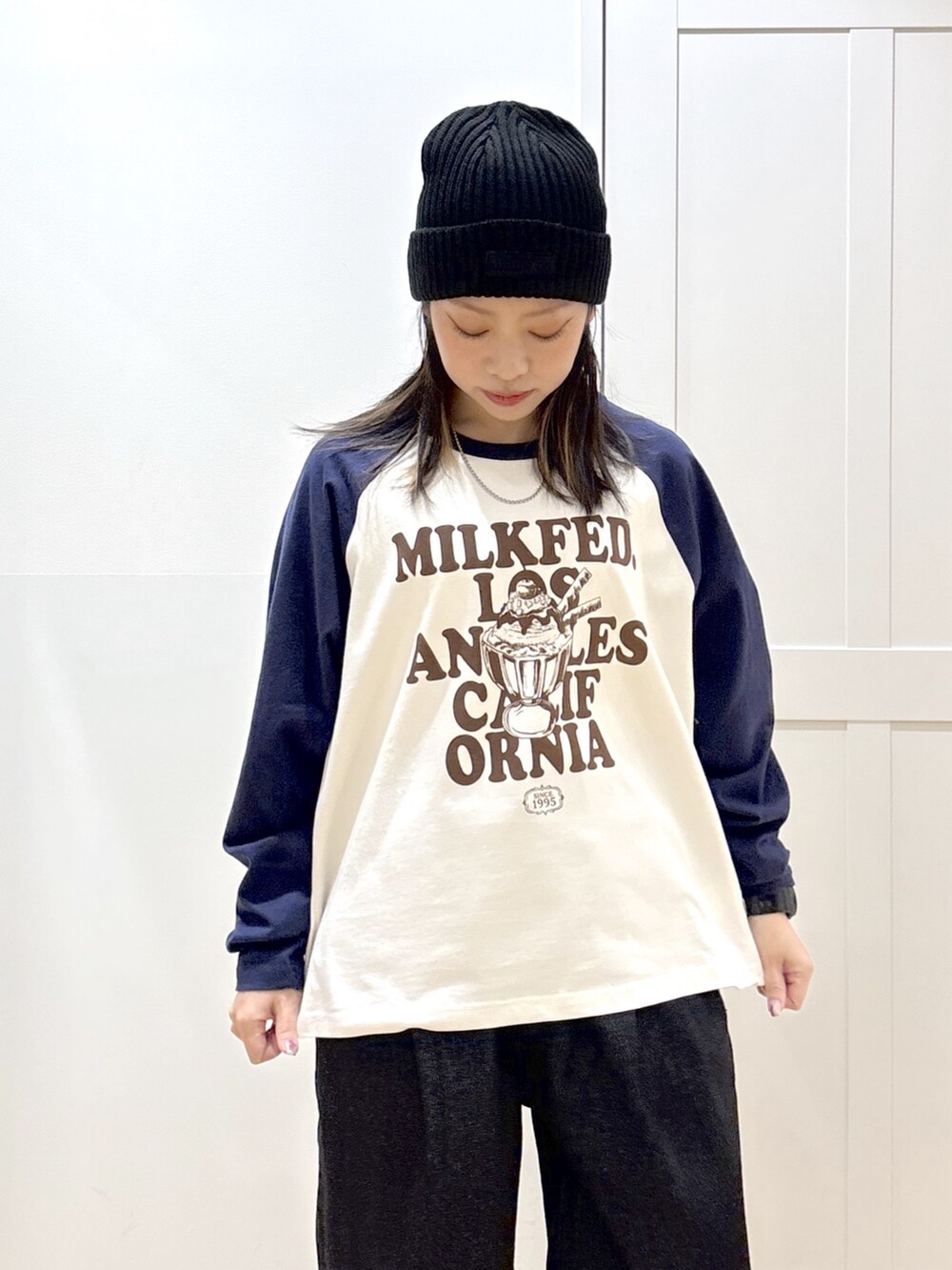 ブラック系のデニムパンツ、ホワイト系のTシャツ/カットソー、グレー系のショルダーバッグを着用したレディースの冬コーディネートの6枚目の写真