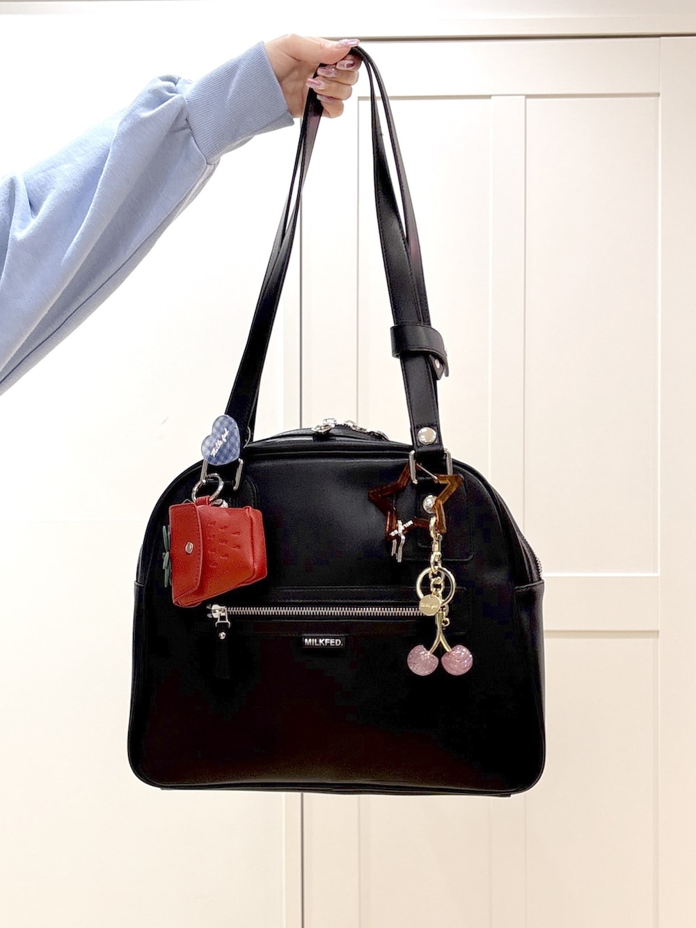 ブラック系のブーツ、ブルー系のスウェットパンツ、グリーン系のボストンバッグを着用したレディースの春コーディネートの7枚目の写真