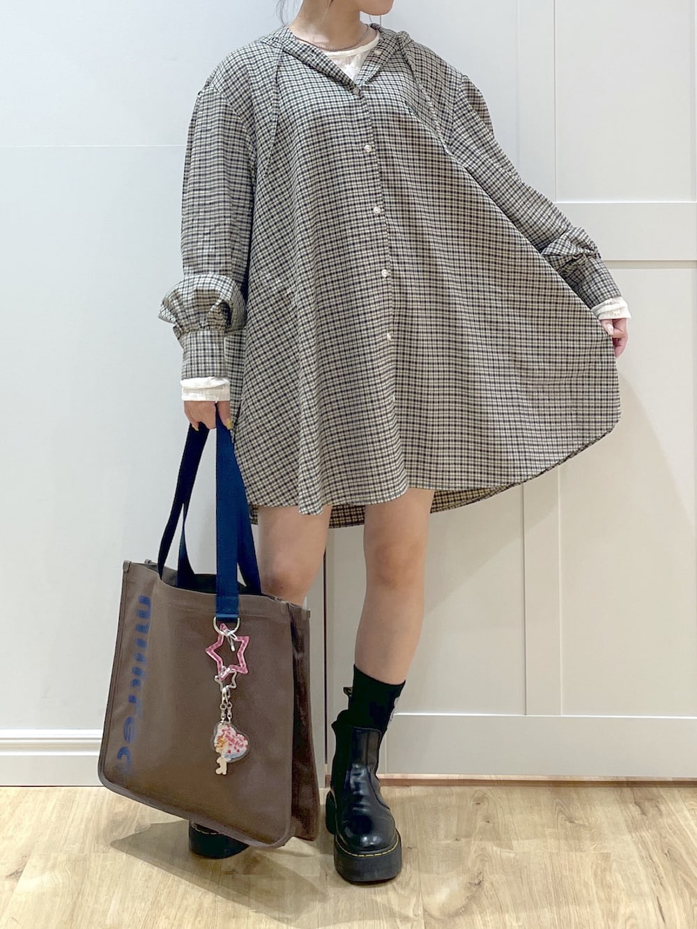 ブラック系のブーツ、ホワイト系のTシャツ/カットソー、ベージュ系のシャツ/ブラウスを着用したレディースの夏コーディネートの3枚目の写真