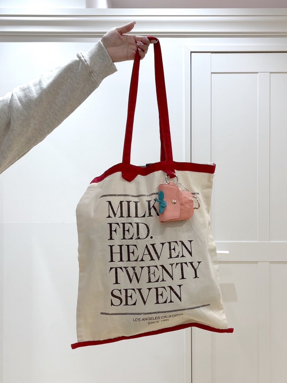 ホワイト系のトートバッグ、ベージュ系のスウェット、ベージュ系のスカートを着用したレディースの冬コーディネートの7枚目の写真