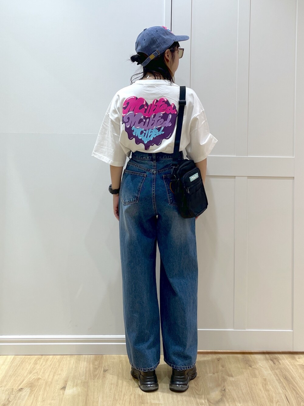 グリーン系のショルダーバッグ、ブラック系のサンダル、ホワイト系のTシャツ/カットソーを着用したレディースの夏コーディネートの2枚目の写真