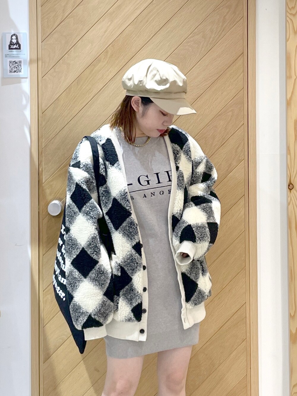 ホワイト系のカーディガン/ボレロ、グレー系のニット/セーター、ブラック系のブーツを着用したレディースの秋コーディネートの2枚目の写真