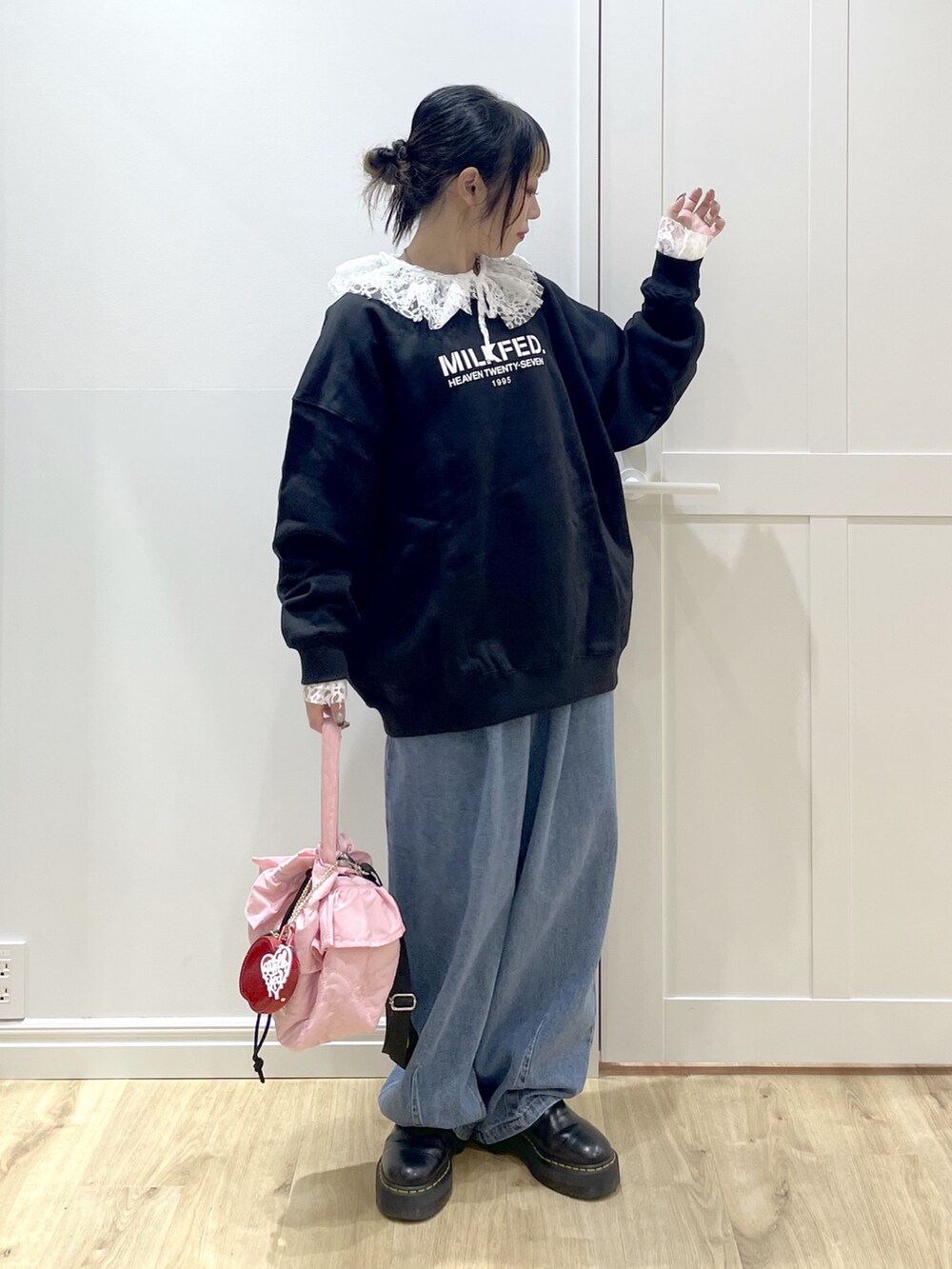 ブラック系のスウェット、ブルー系のデニムパンツ、ホワイト系のシャツ/ブラウスを着用したレディースの冬コーディネートの2枚目の写真