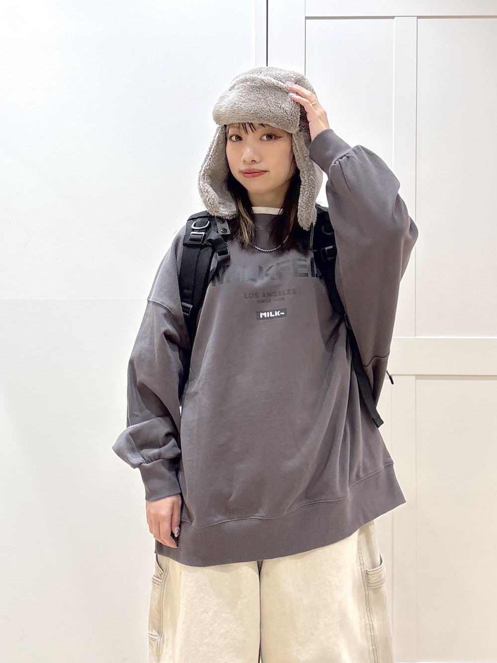 ホワイト系のデニムパンツ、グレー系のスウェット、ブラック系のバックパック/リュックを着用したレディースの冬コーディネートの4枚目の写真