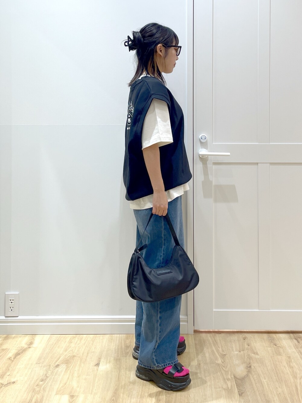 ブラック系のベスト、ブルー系のデニムパンツ、ホワイト系のTシャツ/カットソーを着用したレディースの夏コーディネートの4枚目の写真