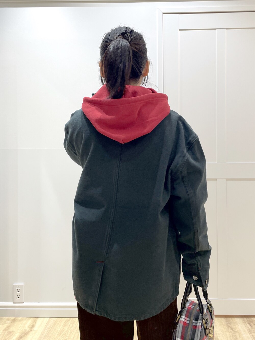 ブラック系のTシャツ/カットソー、レッド系のパーカー、ブラック系のブルゾンを着用したレディースの秋コーディネートの5枚目の写真