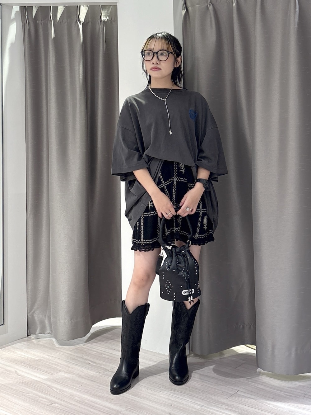 ブラック系のブーツ、ブラック系のショルダーバッグ、ブラック系のカーディガン/ボレロを着用したレディースの夏コーディネートの2枚目の写真