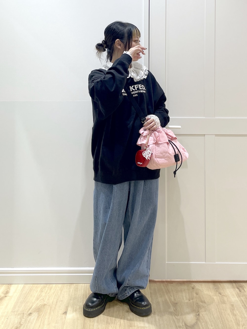 ブラック系のスウェット、ブルー系のデニムパンツ、ホワイト系のシャツ/ブラウスを着用したレディースの冬コーディネートの4枚目の写真