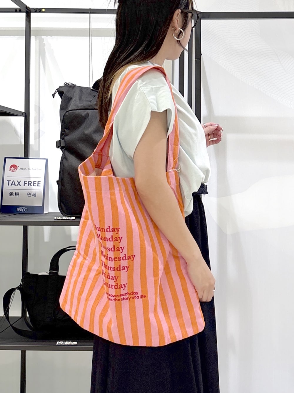 ブルー系のスカート、グリーン系のTシャツ/カットソー、シルバー系のスニーカーを着用したレディースの春コーディネートの5枚目の写真