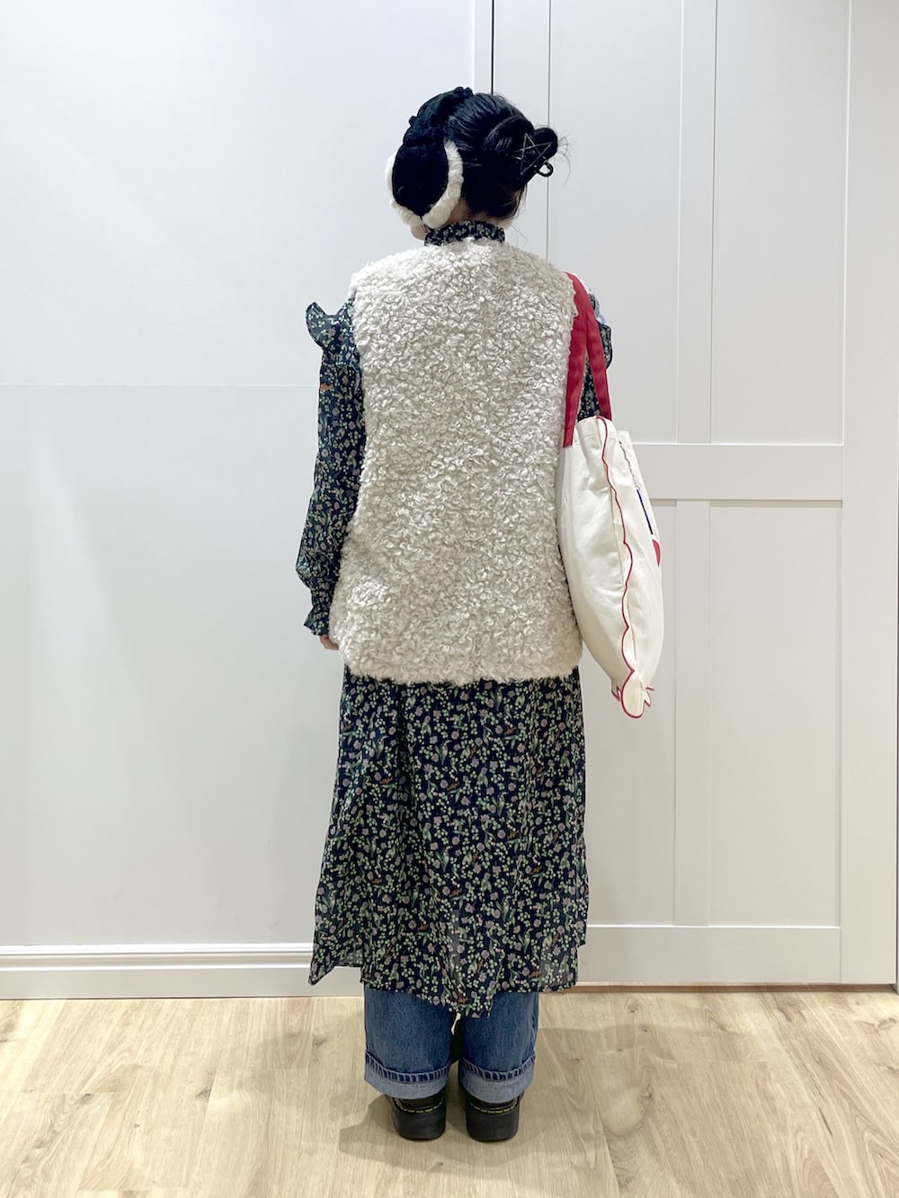 ブルー系のワンピース、ブルー系のデニムパンツ、ブラック系のブーツを着用したレディースの冬コーディネートの5枚目の写真