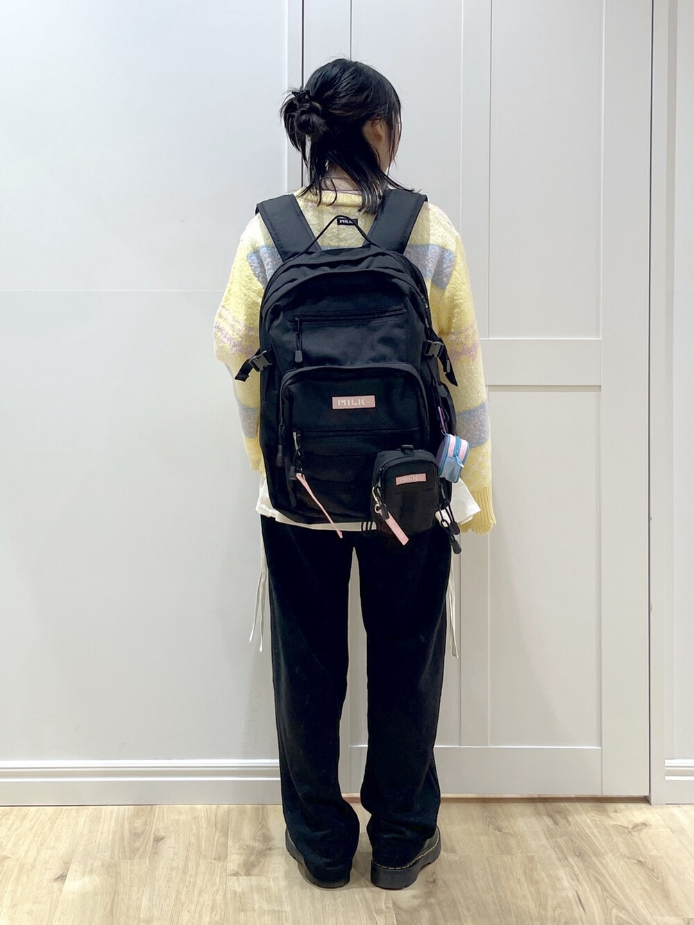ピンク系のTシャツ/カットソー、イエロー系のニット/セーター、ブラック系のスウェットパンツを着用したレディースの秋コーディネートの2枚目の写真