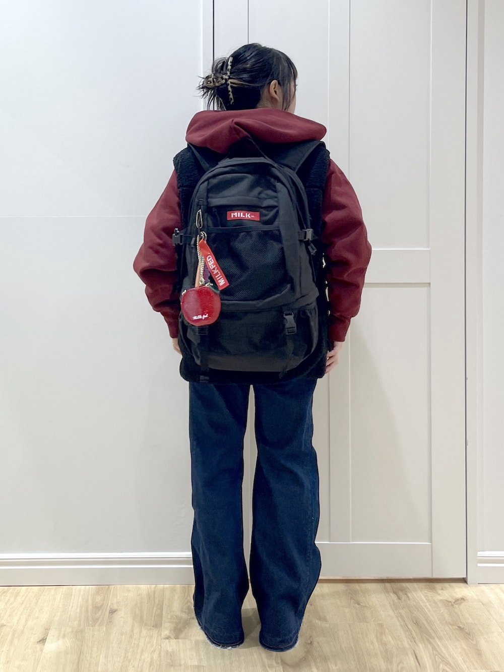 ベージュ系のブーツ、ブルー系のデニムパンツ、ブラック系のベストを着用したレディースの秋コーディネートの2枚目の写真