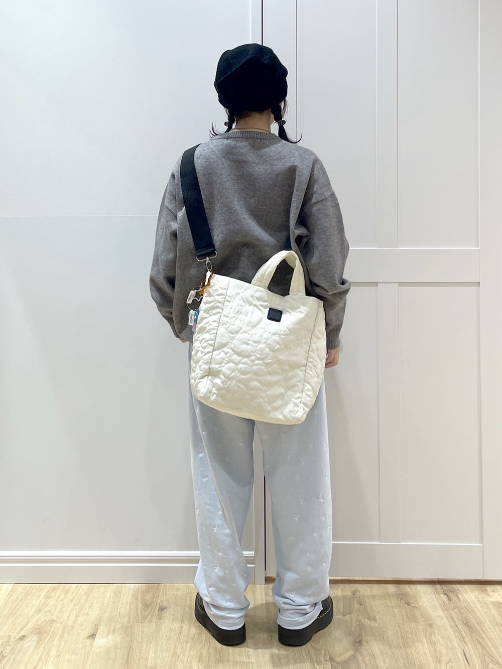 ブルー系のスウェットパンツ、グレー系のニット/セーター、ホワイト系のショルダーバッグを着用したレディースの秋コーディネートの4枚目の写真
