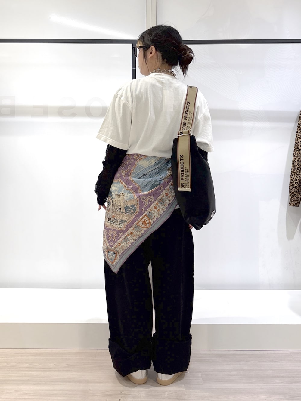 ブラック系のデニムパンツ、シルバー系のスニーカー、ホワイト系のTシャツ/カットソーを着用したレディースの春コーディネートの4枚目の写真