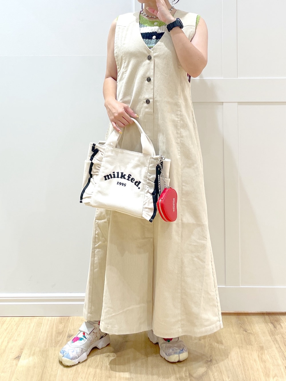 ベージュ系のワンピース、パープル系のニット/セーター、ホワイト系のショルダーバッグを着用したレディースの秋コーディネートの3枚目の写真