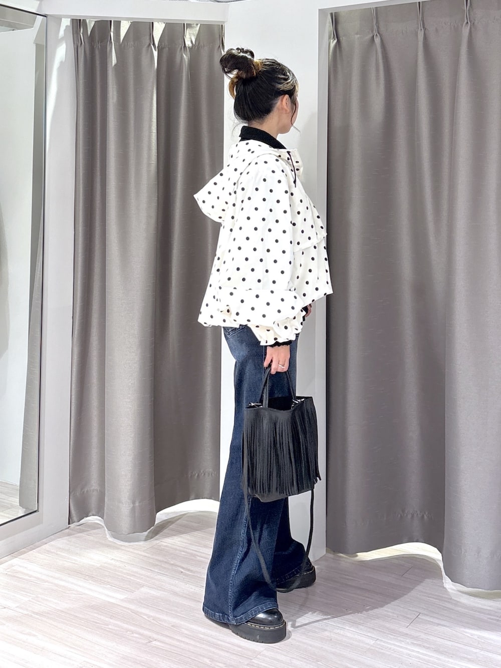 ブラック系のシャツ/ブラウス、ブルー系のデニムパンツ、ブラック系のブーツを着用したレディースの秋コーディネートの2枚目の写真