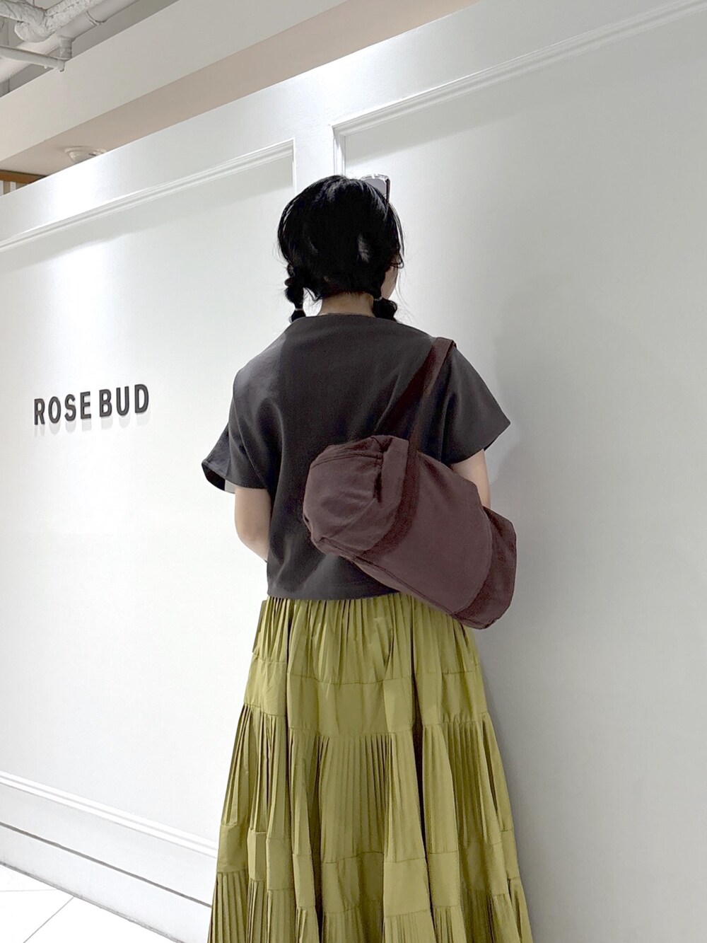 ブラック系のTシャツ/カットソー、ブラウン系のボストンバッグ、イエロー系のスカートを着用したレディースの夏コーディネートの6枚目の写真