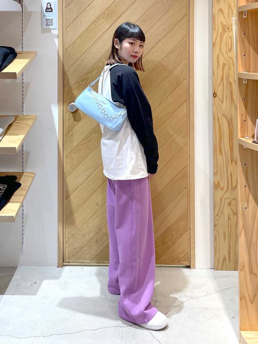 ブルー系のハンドバッグ、パープル系のスウェットパンツ、ブラック系のTシャツ/カットソーを着用したレディースの冬コーディネートの2枚目の写真