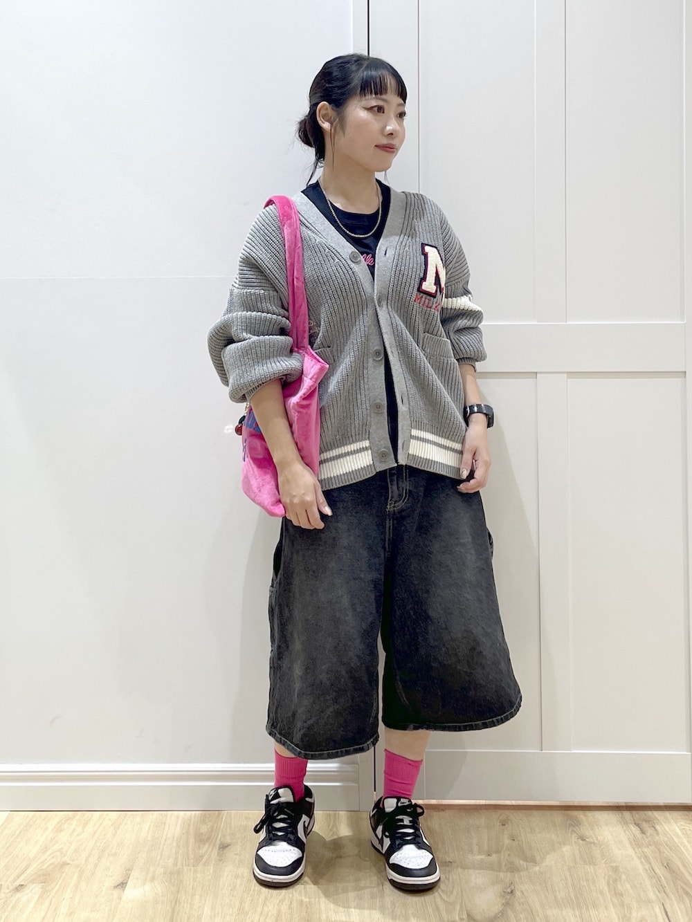 ホワイト系のスニーカー、ブラック系のデニムパンツ、グレー系のカーディガン/ボレロを着用したレディースの秋コーディネートの4枚目の写真