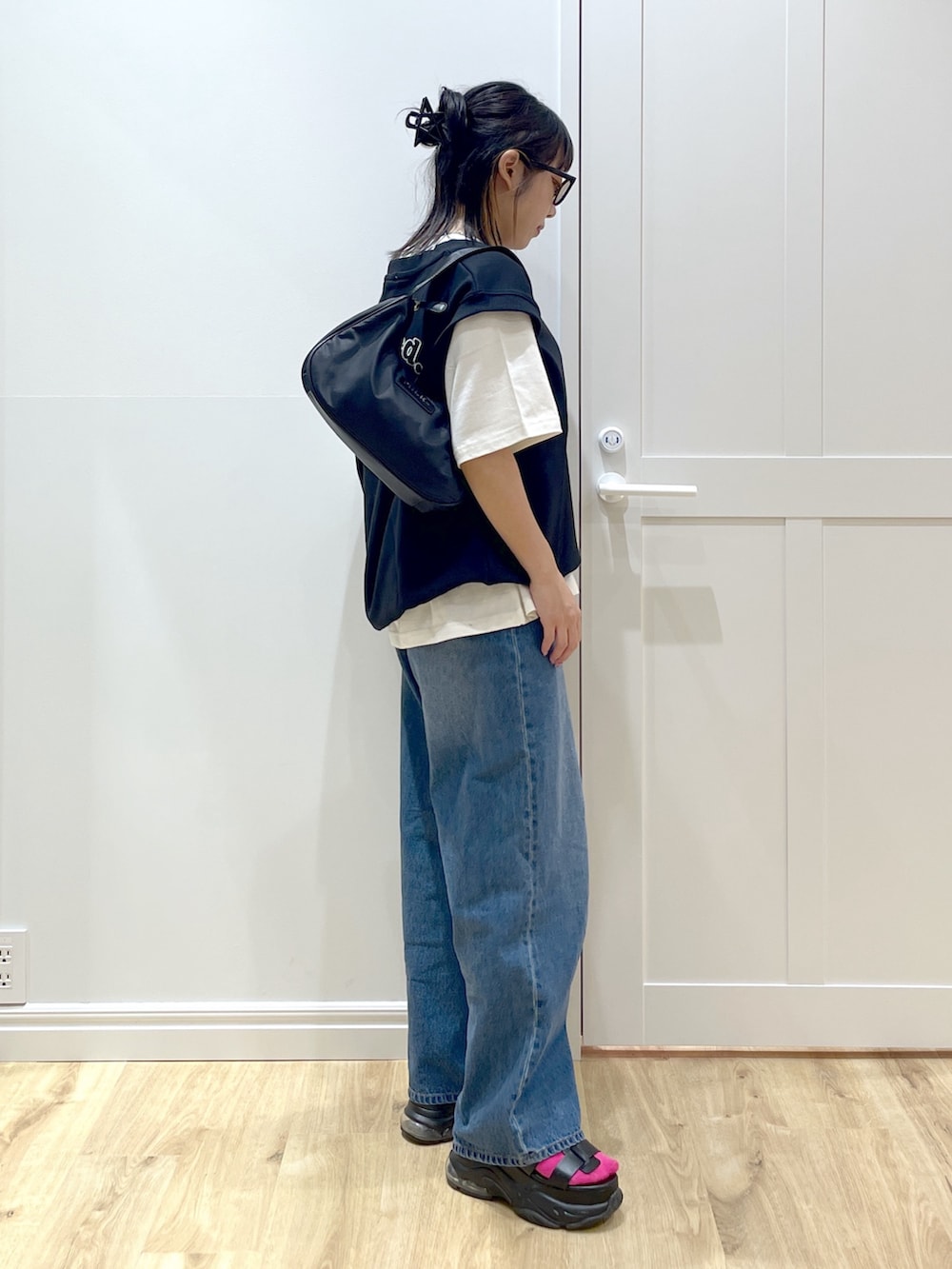 ブラック系のベスト、ブルー系のデニムパンツ、ホワイト系のTシャツ/カットソーを着用したレディースの夏コーディネートの2枚目の写真