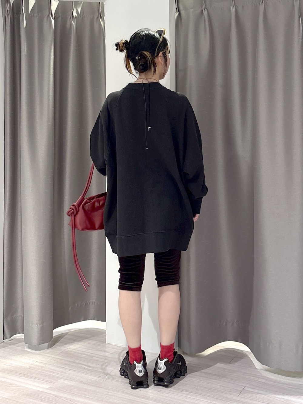 ブラック系のスウェット、ブラウン系のその他パンツ、レッド系のハンドバッグを着用したレディースの秋コーディネートの3枚目の写真