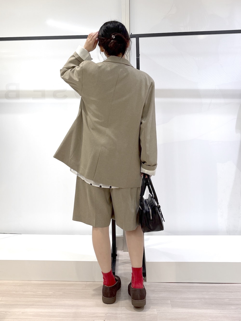 ホワイト系のシャツ/ブラウス、ブラック系のニット/セーター、ベージュ系のテーラードジャケットを着用したレディースの春コーディネートの3枚目の写真