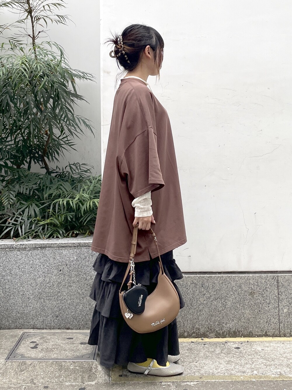 ブラック系のスカート、ホワイト系のTシャツ/カットソー、ブラウン系のTシャツ/カットソーを着用したレディースの秋コーディネートの3枚目の写真