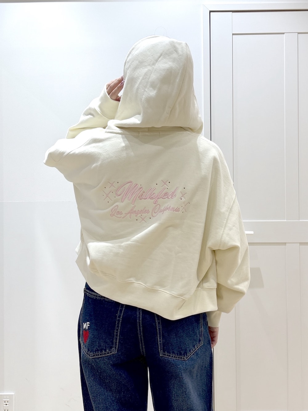 ブラック系のブーツ、ブルー系のデニムパンツ、ホワイト系のパーカーを着用したレディースの春コーディネートの6枚目の写真