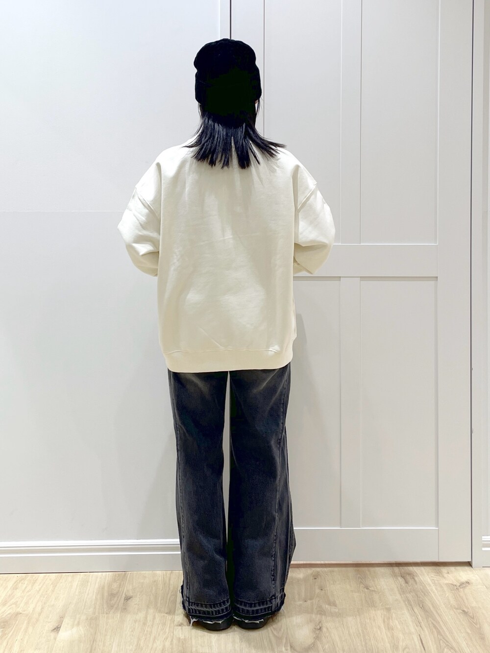 ブラック系のデニムパンツ、レッド系のワンピース、ホワイト系のスウェットを着用したレディースの秋コーディネートの7枚目の写真