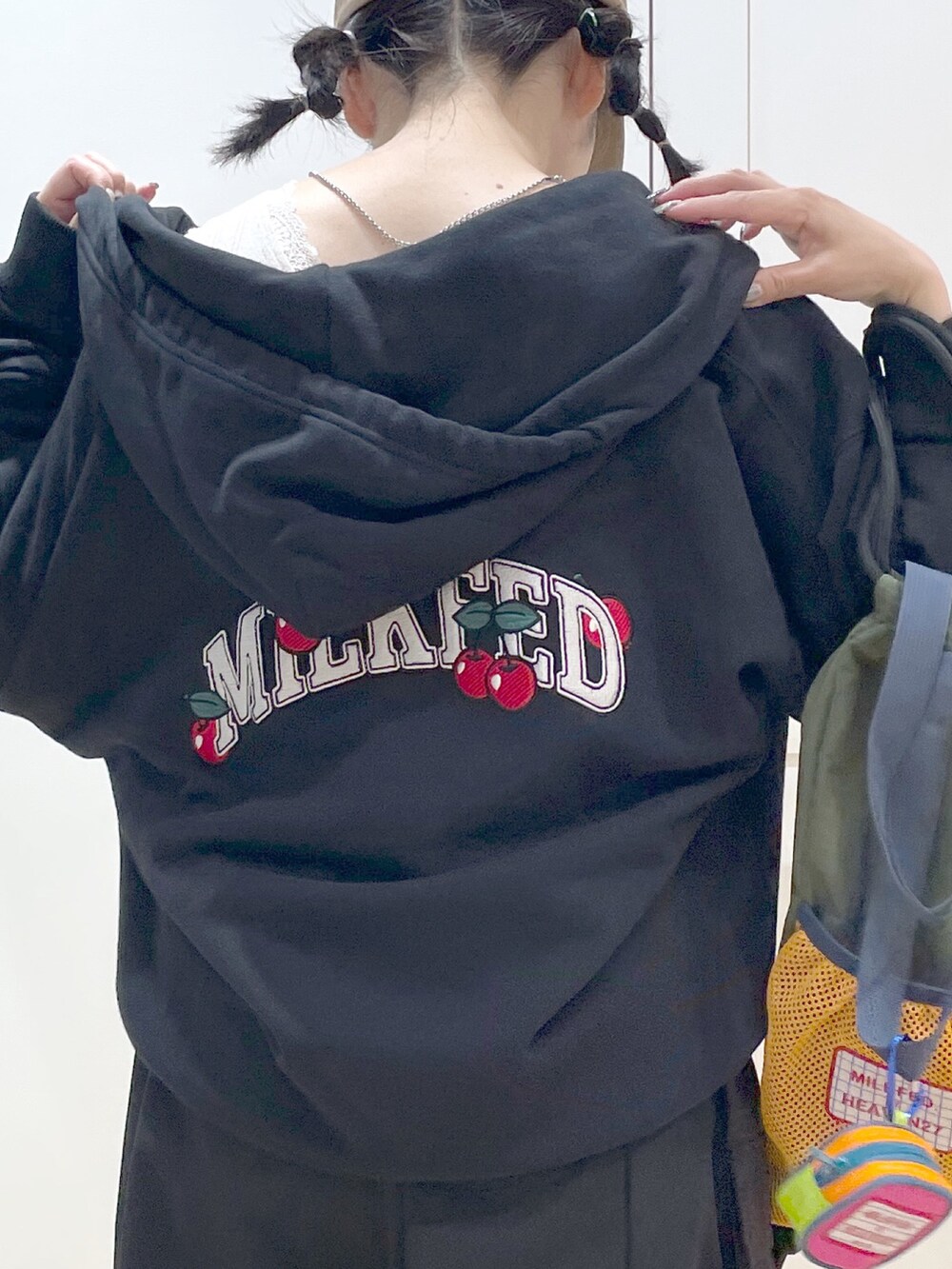 グリーン系のバックパック/リュック、ブラック系のパーカー、ホワイト系のタンクトップを着用したレディースの春コーディネートの4枚目の写真