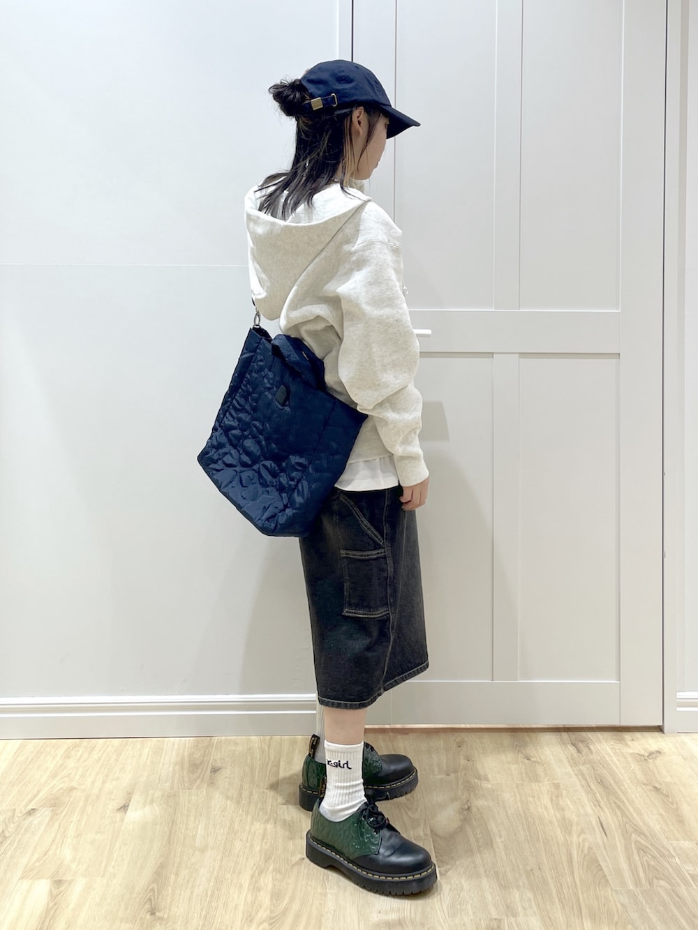 ブルー系のショルダーバッグ、ブラック系のデニムパンツ、ベージュ系のパーカーを着用したレディースの秋コーディネートの3枚目の写真