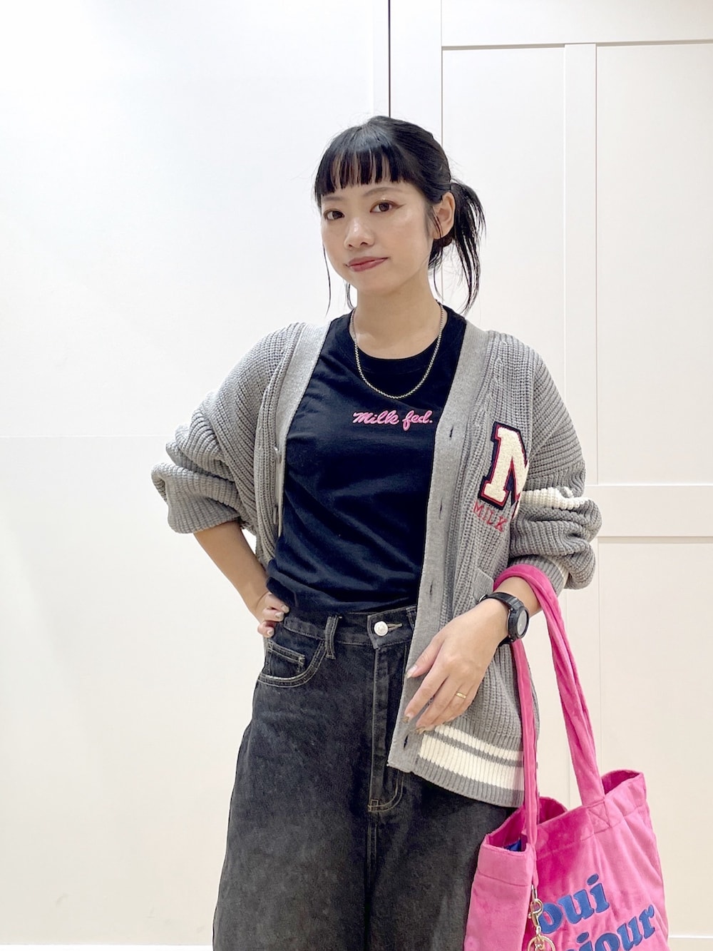 ホワイト系のスニーカー、ブラック系のデニムパンツ、グレー系のカーディガン/ボレロを着用したレディースの秋コーディネートの5枚目の写真