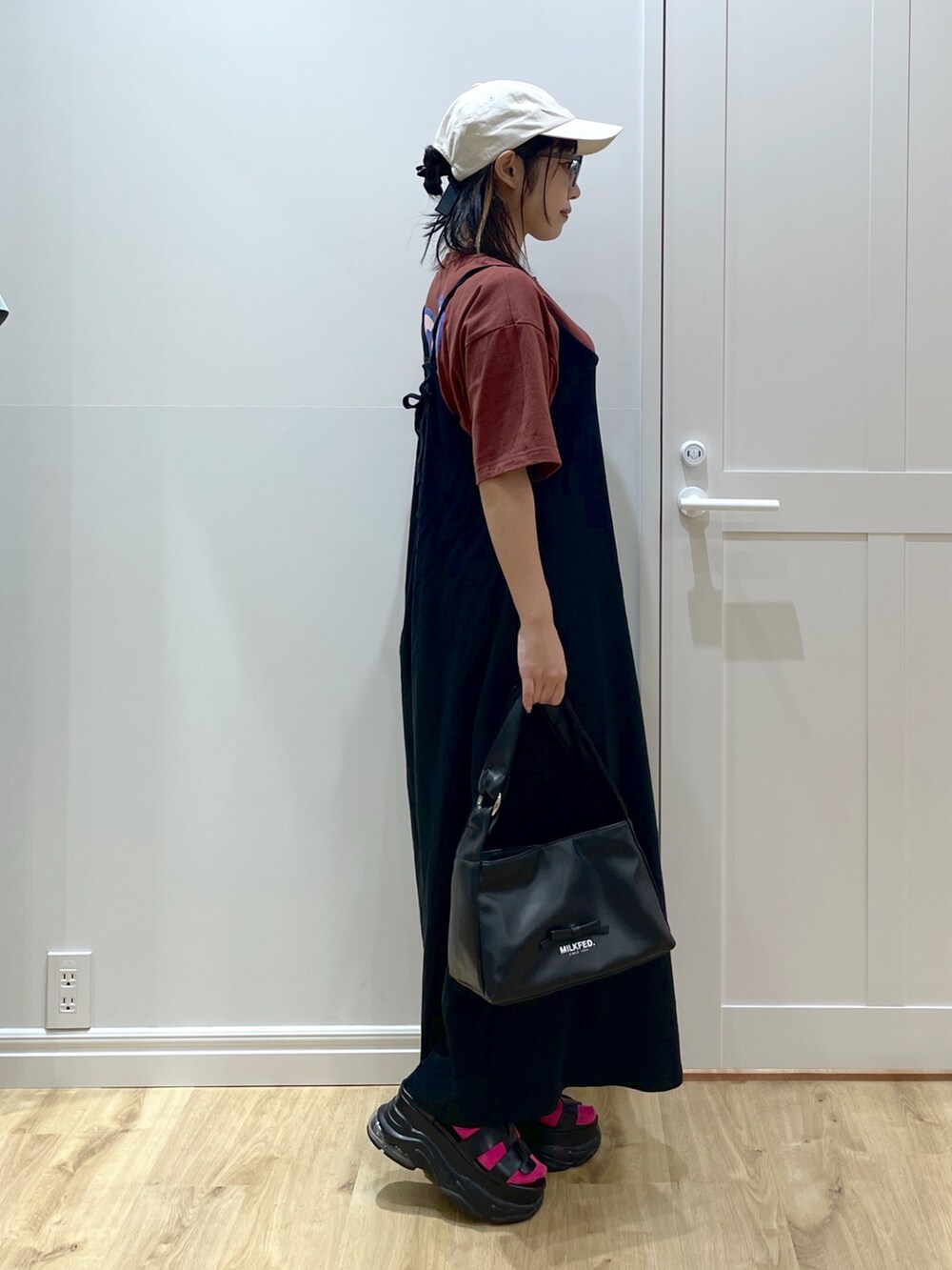 ブラック系のワンピース、ブラウン系のTシャツ/カットソー、ブラック系のサンダルを着用したレディースの夏コーディネートの3枚目の写真